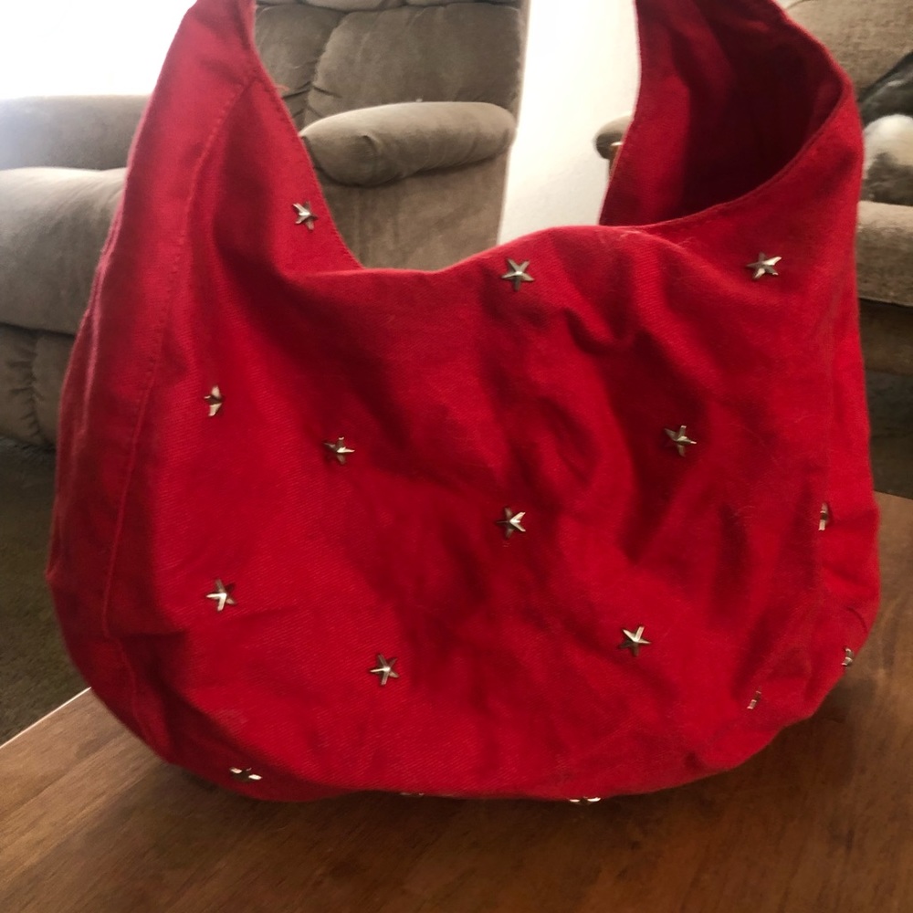 Red fabric purse silver star details one pocket with button close. New